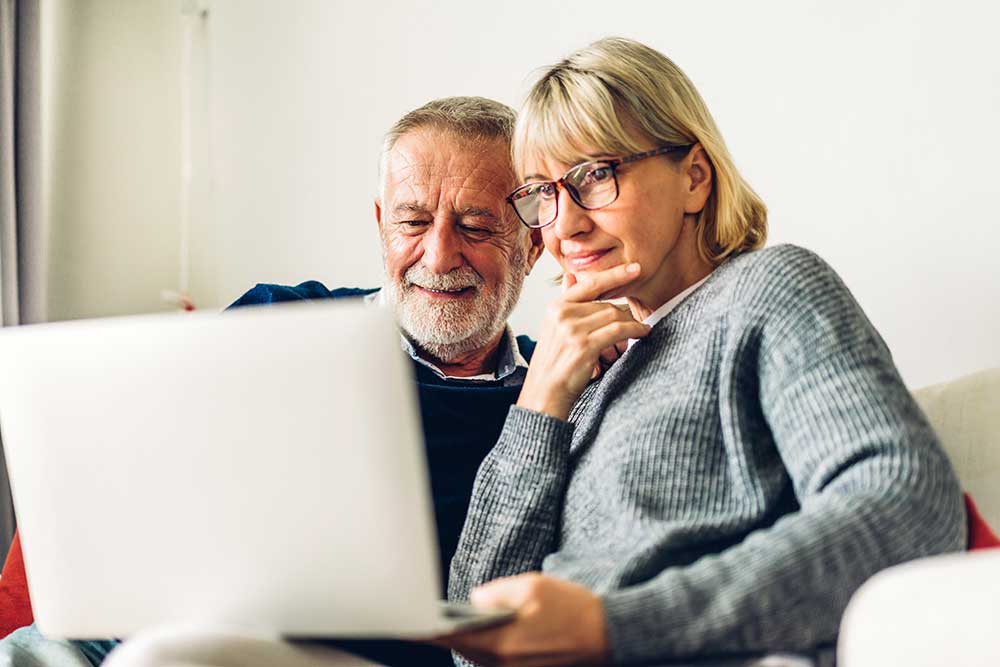 ask-ron-telehealth-services-husband-and-wife-looking-at-laptop